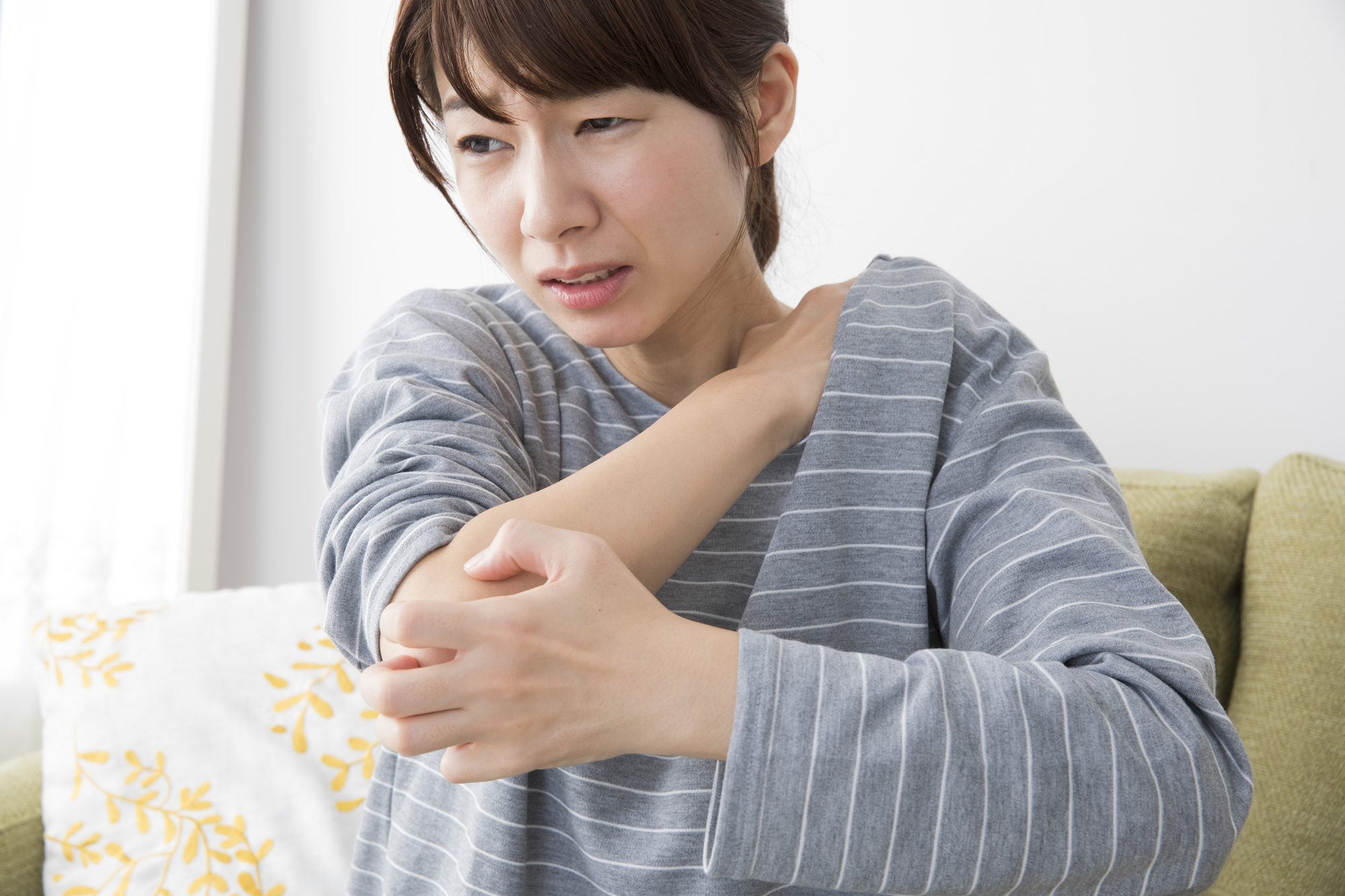 首の痛みを感じる女性│整形外科で対応可能な症状イメージ