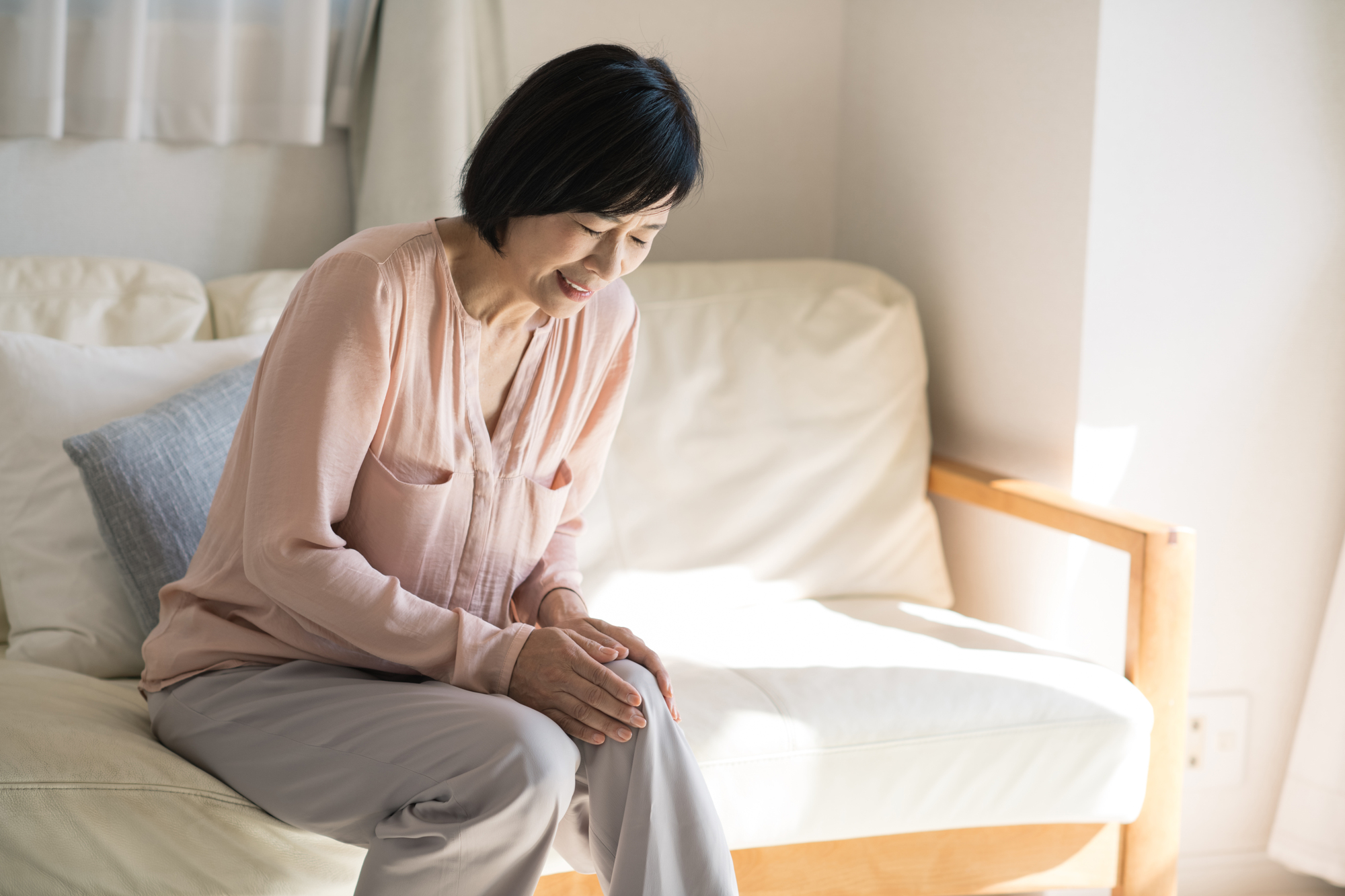 膝の痛みによって座り込んでしまう女性│鵞足炎の症状