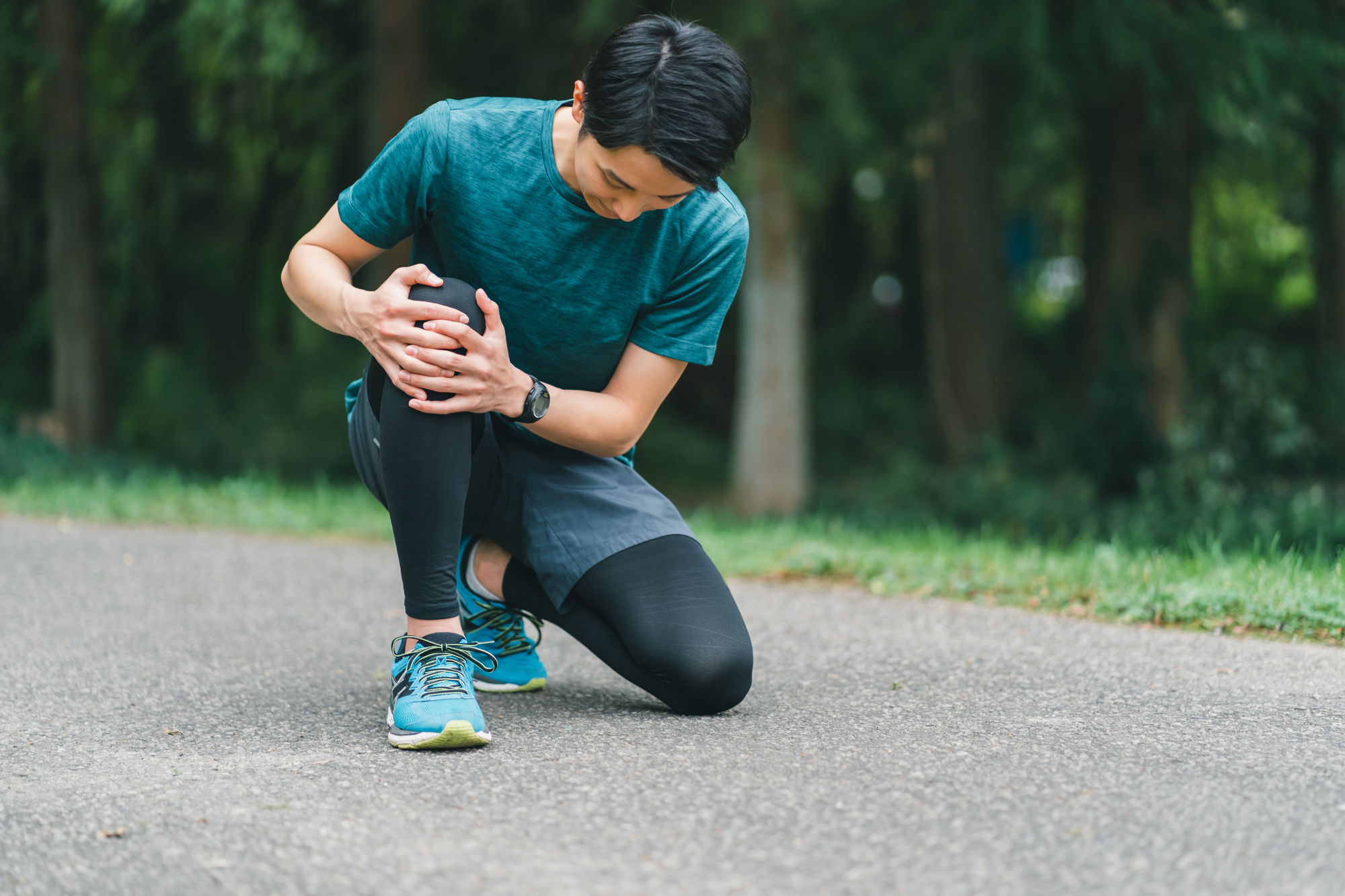 ランナー膝による痛みでランニング中にうずくまる男性│ランナー膝の症状