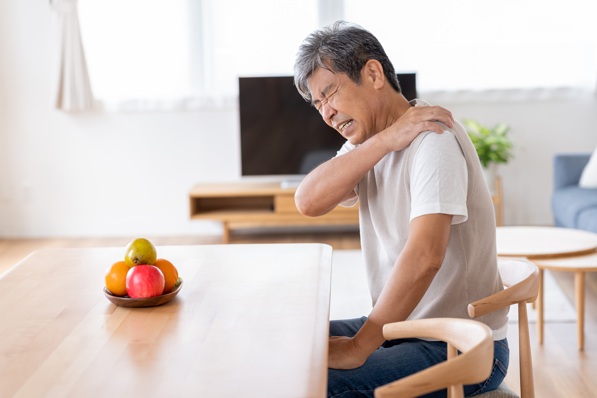 安静時でも肩に強い痛みを感じている男性