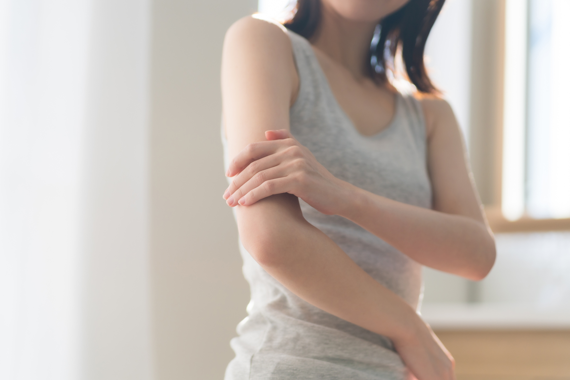 肘の痛みを感じる女性│整形外科で対応可能な症状イメージ