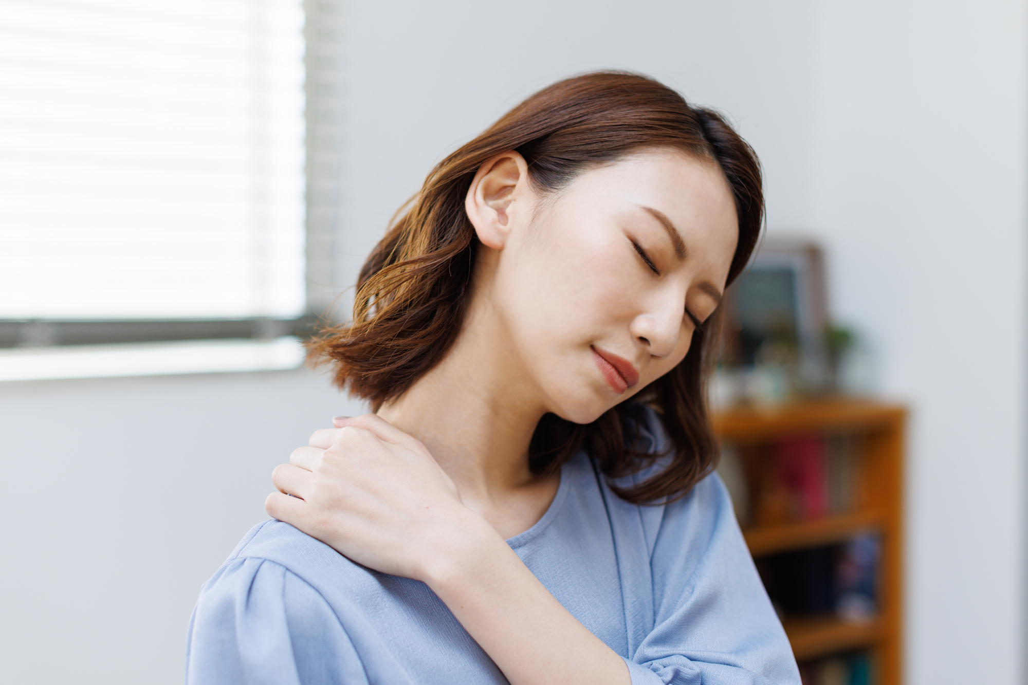 腕を上げると肩に痛みを感じる女性